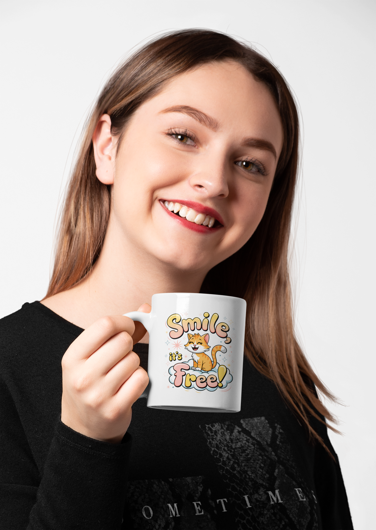 Smiling woman with red lipstick holding a white mug featuring a cheerful cat and the phrase “Smile, it’s Free!” in playful lettering.