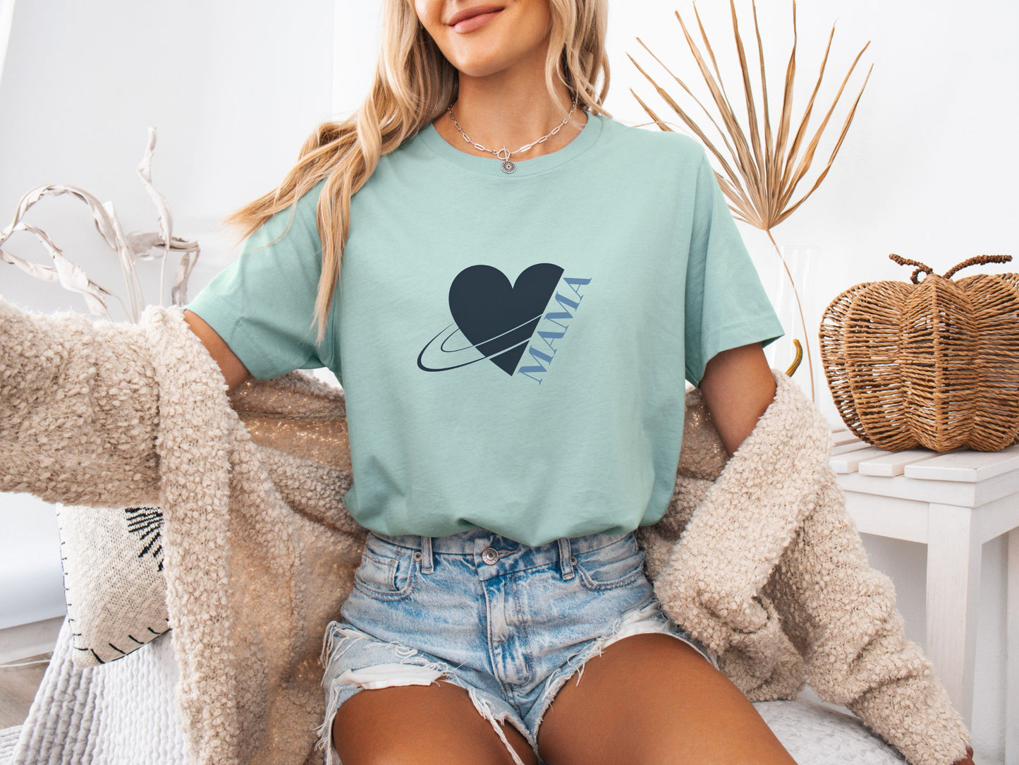 Woman wearing dusty blue MAMA shirt with heart and planet illustration