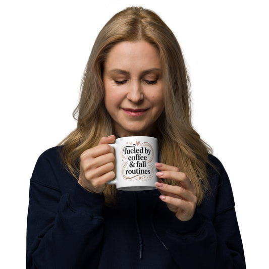 Woman holding a mug with text "Fueled by Coffee & Fall Routines" on a white background