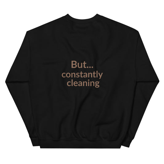 Black sweatshirt with text 'But... constantly cleaning' on a white background