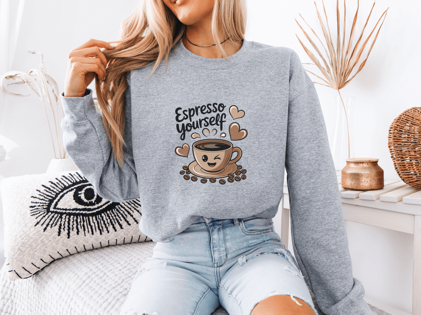 Woman in a gray “Espresso Yourself” sweatshirt featuring a smiling coffee cup with hearts – the perfect cozy gift for coffee-loving moms who run on caffeine and chaos.