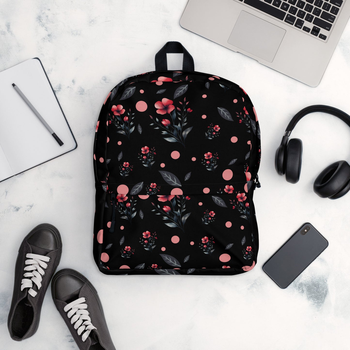 Flat lay of a floral black backpack with red flowers and polka dots
