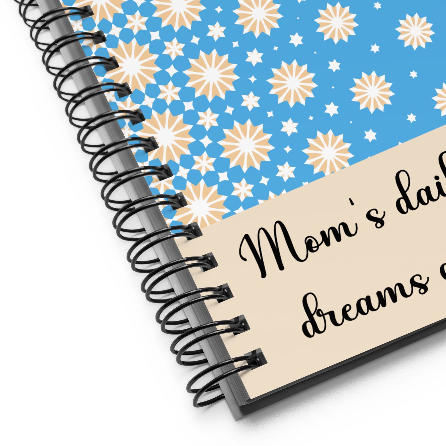 Close-up of blue spiral notebook with yellow and white stars and "Mom’s daily dose of dreams and plans" quote – elegant and practical planner for moms