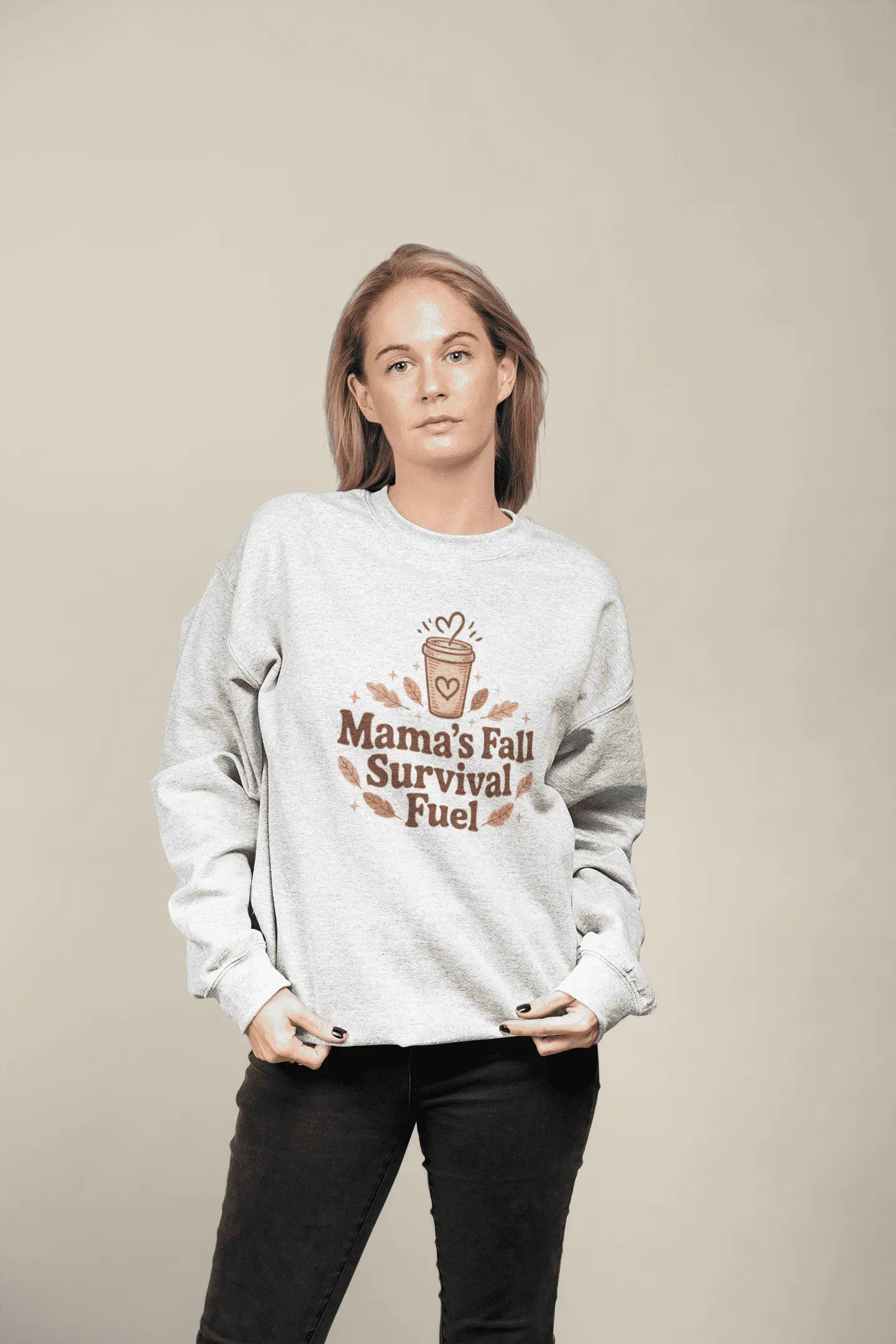 Woman wearing a sweatshirt with 'Mama's Fall Survival Fuel' text and graphic on a beige background