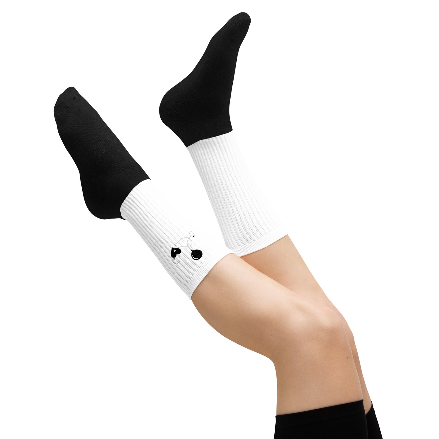 Fun socks with heart and balloon print – worn by model with legs raised on white background