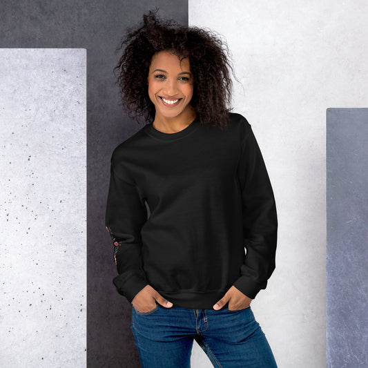 Smiling woman wearing black sweatshirt with floral design detail on the sleeve - front view
