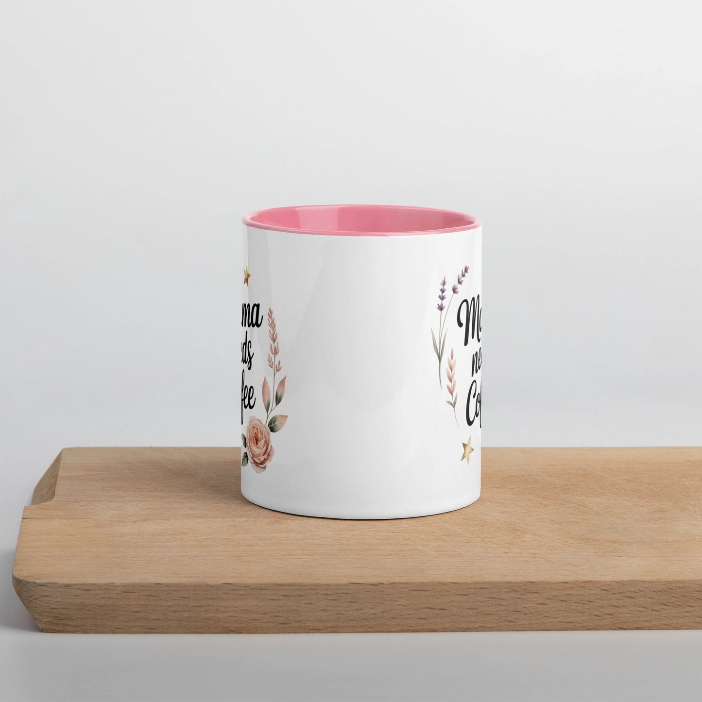 White ceramic mug with โMama Needs Coffeeโ quote, pink inside and handle, centered front view.