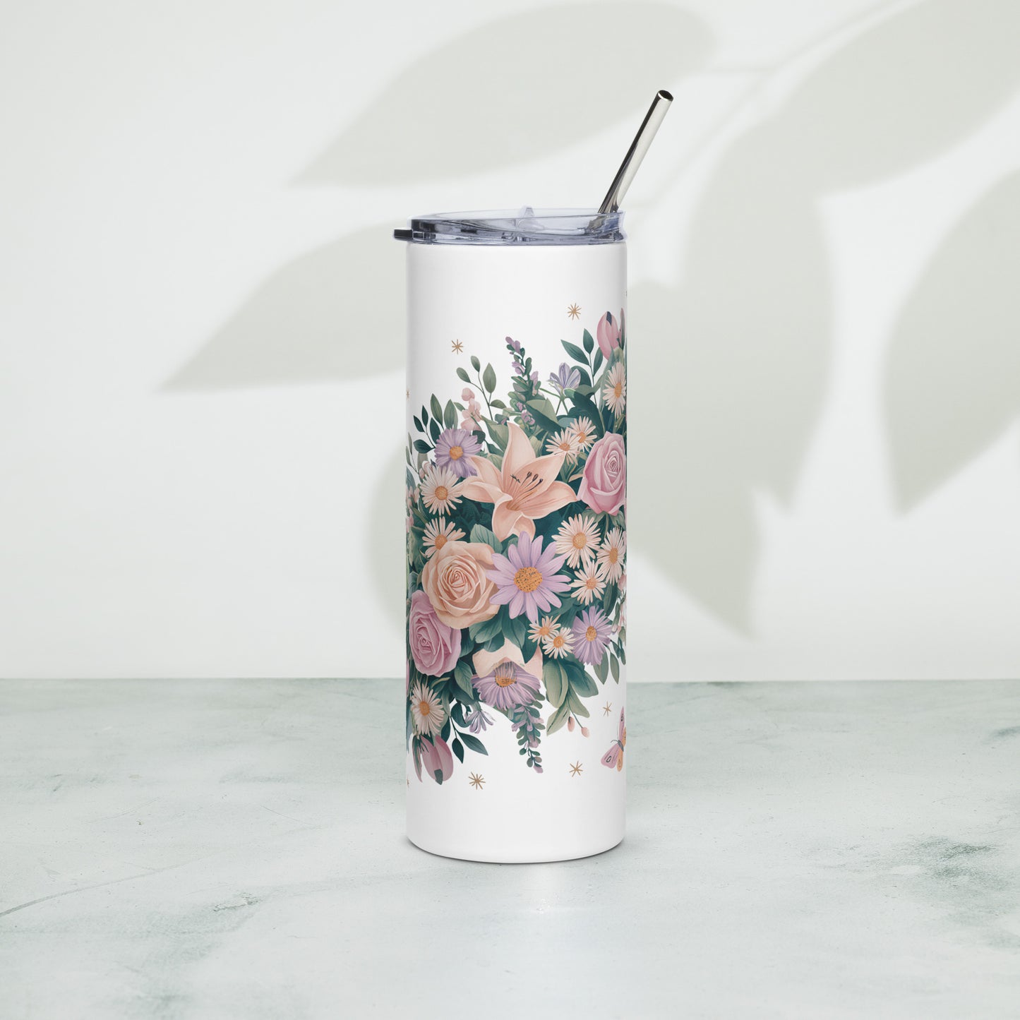 Tall white tumbler with pastel floral, butterfly, and rainbow pattern. Includes metal straw and transparent lid.