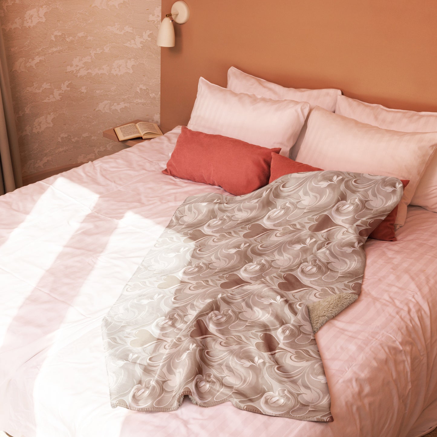 Tan sherpa blanket with elegant cream coffee swirl design draped over a blush pink bed with white and terracotta pillows, in a softly lit room with neutral walls and cozy decor.