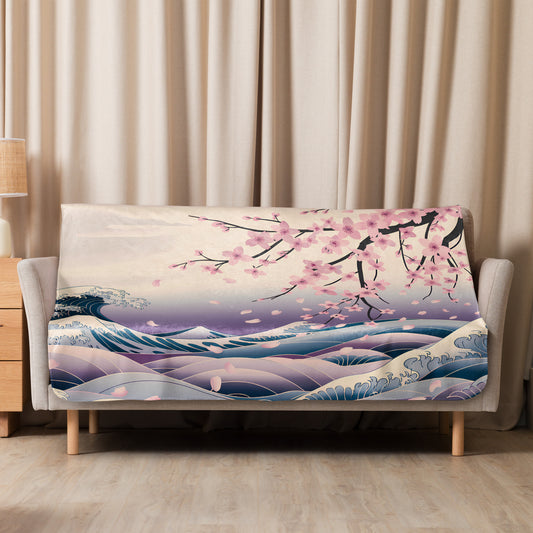 Cherry blossom and wave-patterned sherpa blanket neatly draped over a beige sofa in a cozy living room with soft curtains and a wooden side table.