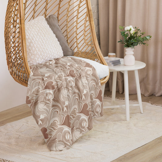 Tan sherpa blanket with cream coffee-inspired swirl design draped over a wicker hanging chair with decorative pillows, next to a white round side table with flowers and books in a soft, neutral-toned reading nook.
