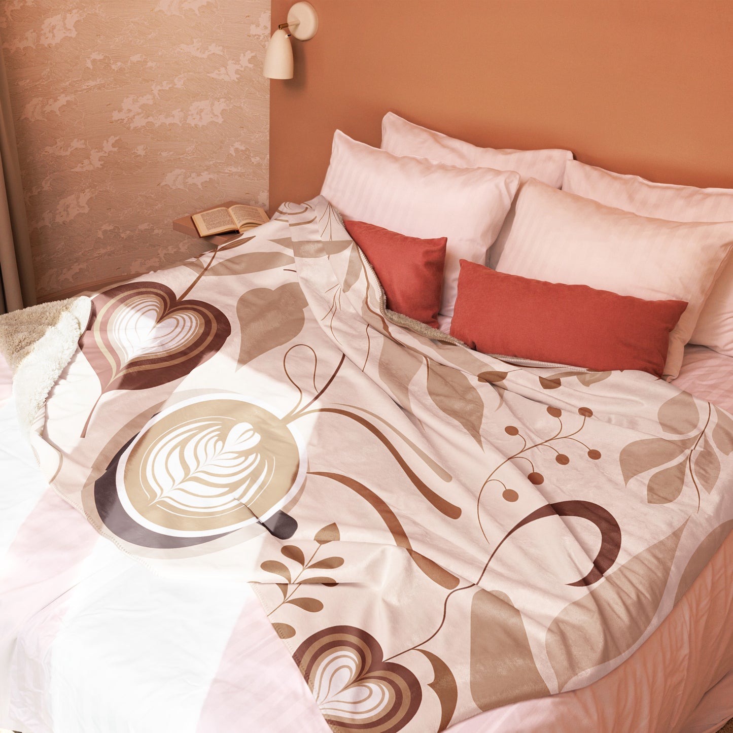 Large tan and brown sherpa blanket featuring large latte art and coffee bean illustrations, styled on a blush pink bed with terracotta and white pillows in a sunlit bedroom with soft, neutral decor.