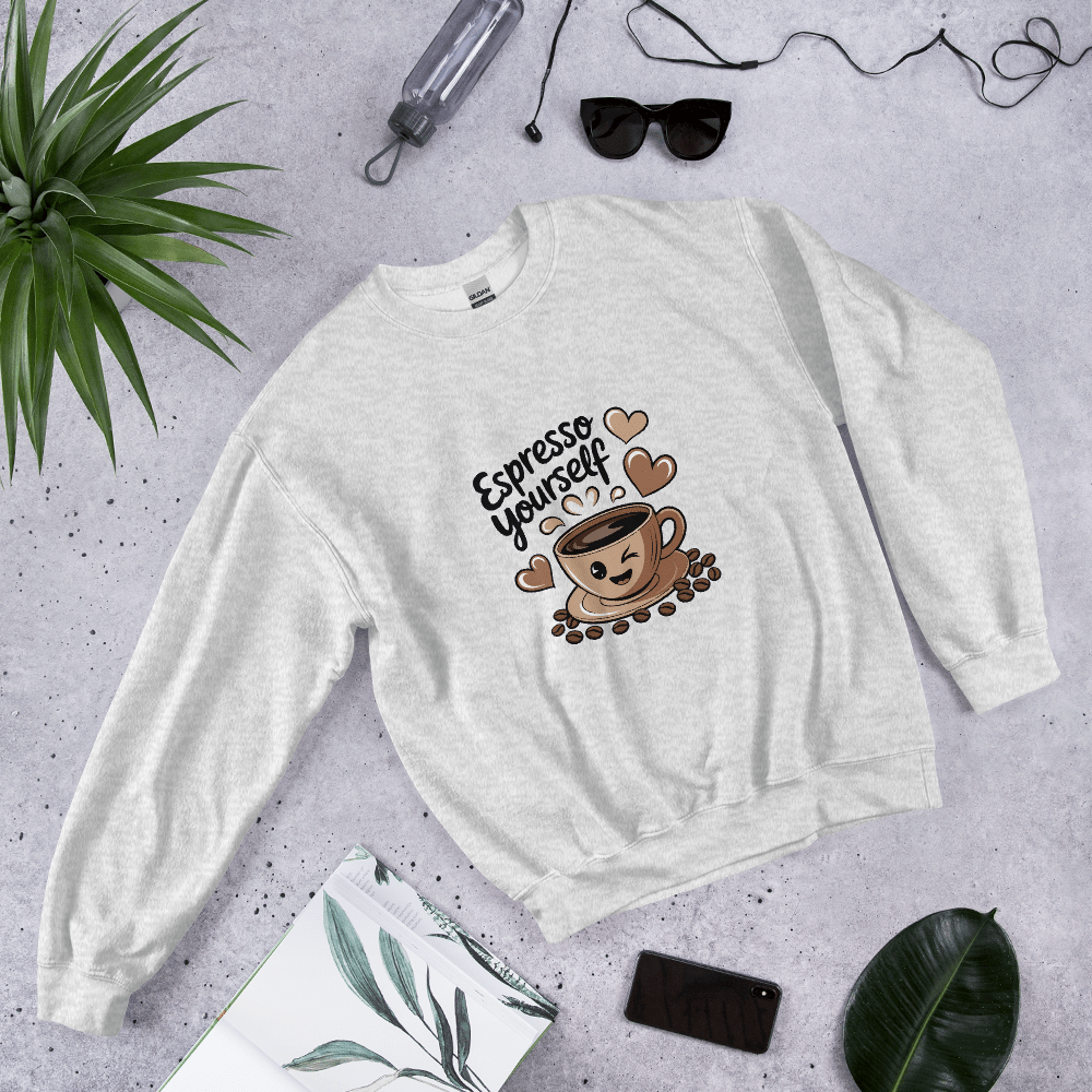 Grey “Espresso Yourself” sweatshirt styled flat lay with sunglasses, water bottle, plant, and notebook – cozy coffee lover gift aesthetic.