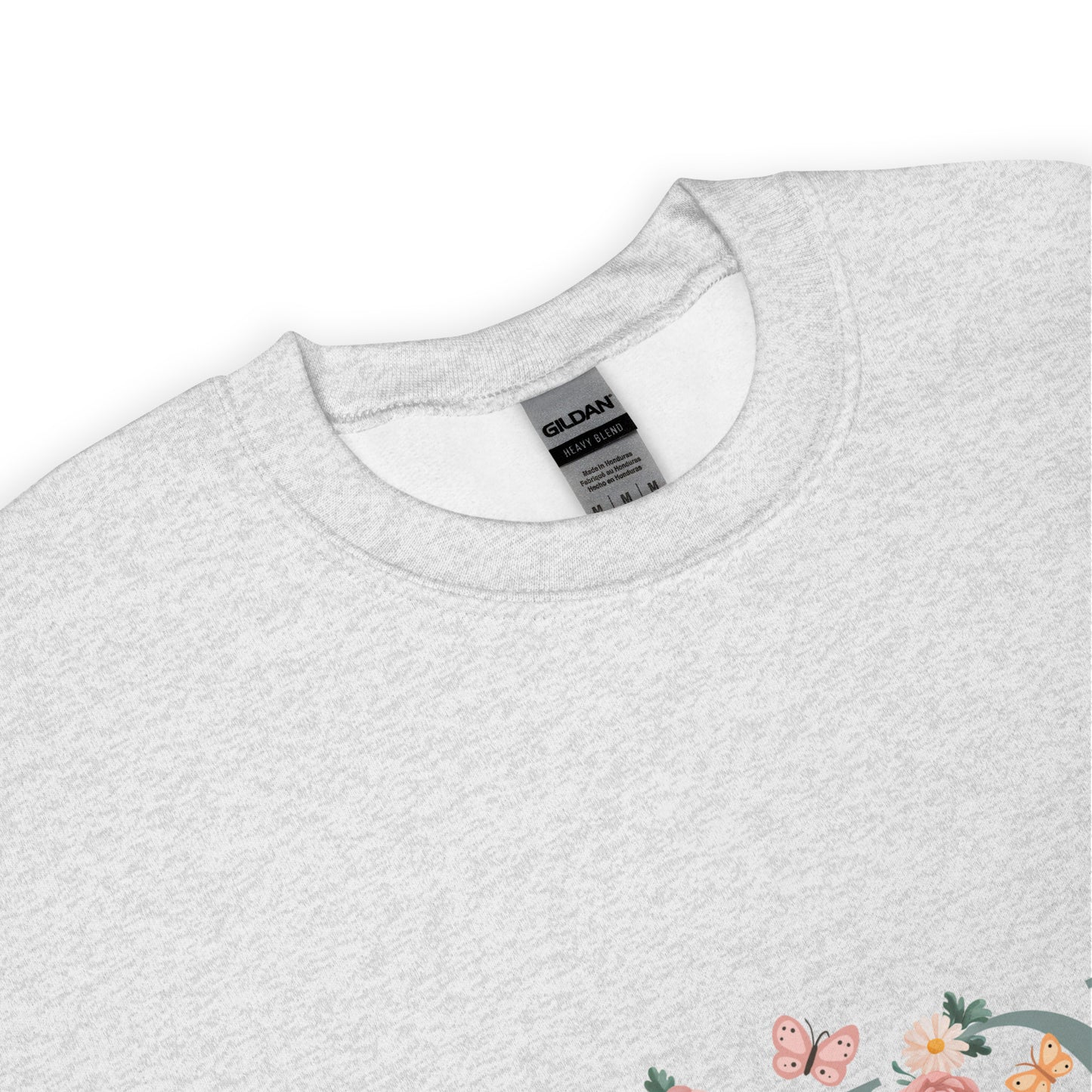 Close-up of a light grey sweatshirt collar with Gildan tag and a peek of floral "MOM" print – cozy and thoughtful gift for moms.