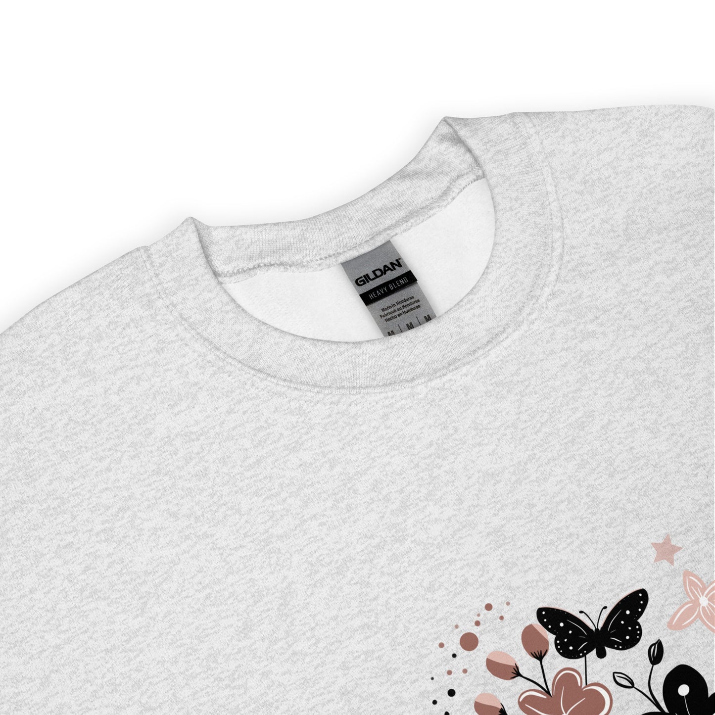 Close-up of a light ash gray Gildan sweatshirt with a floral and butterfly design printed on the lower corner, showing the collar and fabric texture.