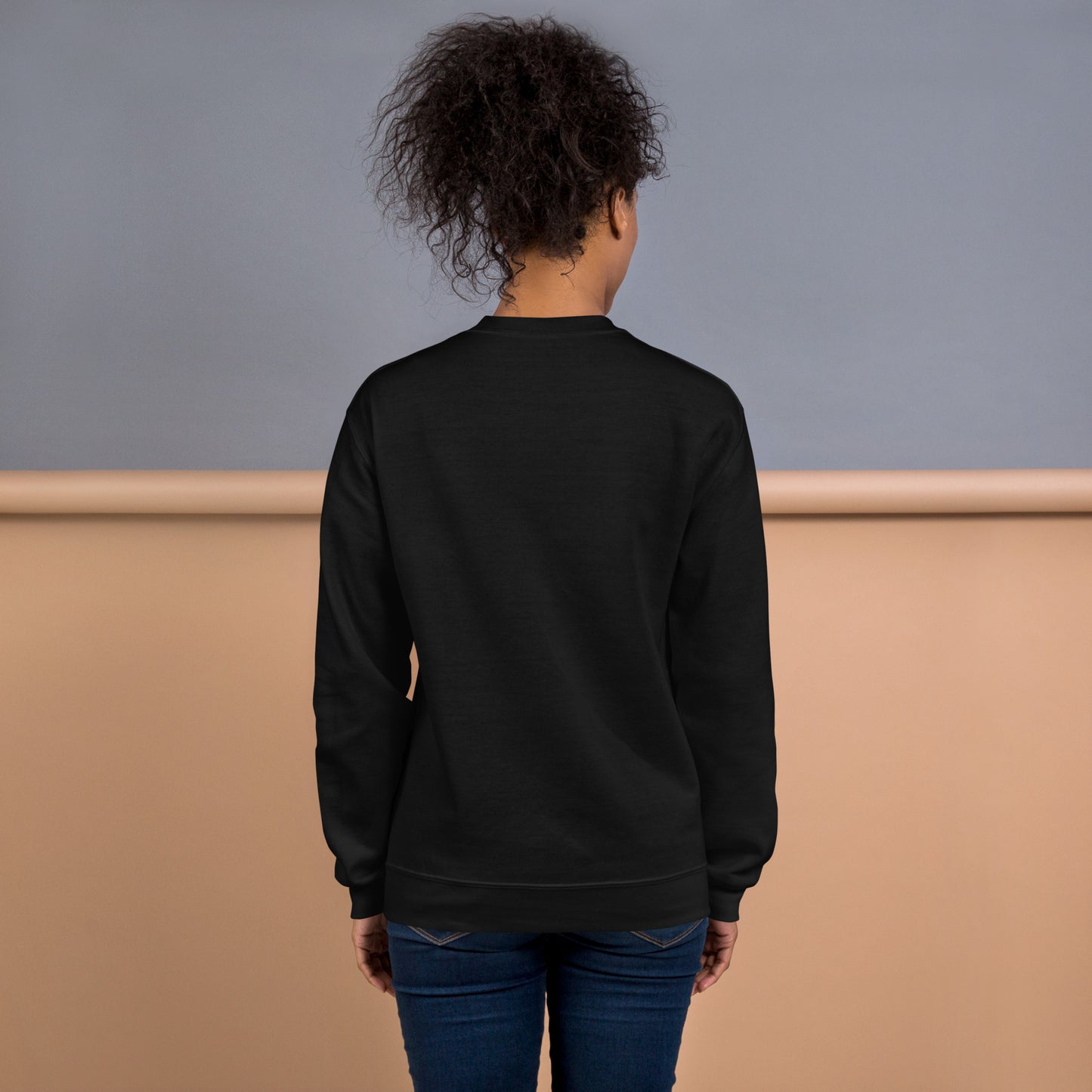 Back view of a woman wearing a black crewneck sweatshirt – soft cotton blend, relaxed fit, no print on the back.