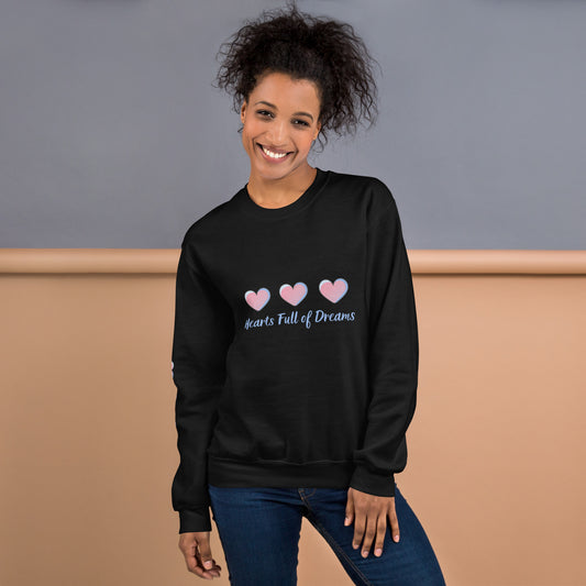Smiling woman wearing a black sweatshirt with a pastel heart design and the phrase “Hearts Full of Dreams”