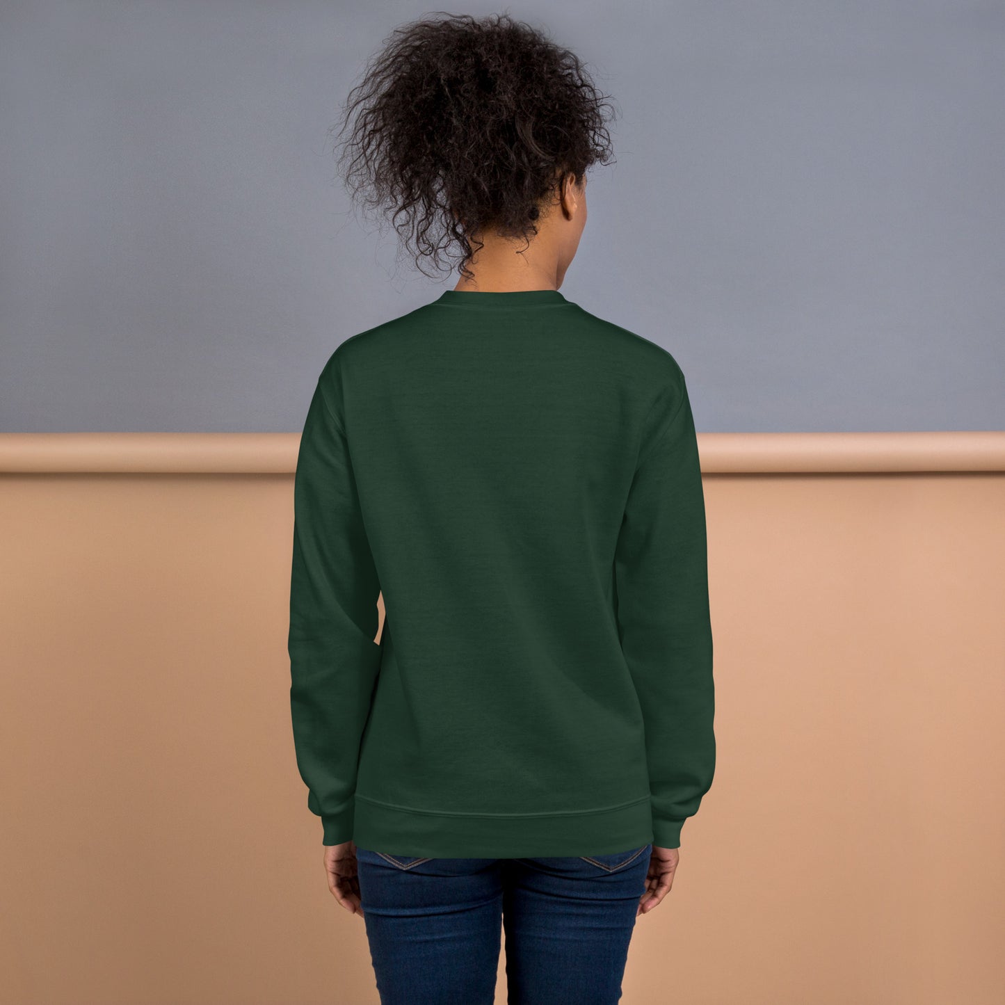 Back view of a woman wearing a forest green crewneck sweatshirt – soft cotton blend, relaxed fit, no print on the back.