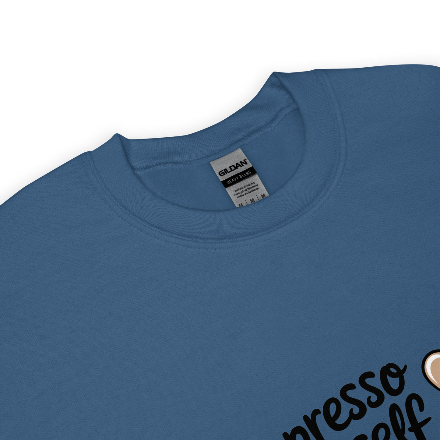 Close-up of a indigo blue crewneck sweatshirt with the phrase “Espresso Yourself” printed in black cursive font and a small coffee cup illustration on the side.