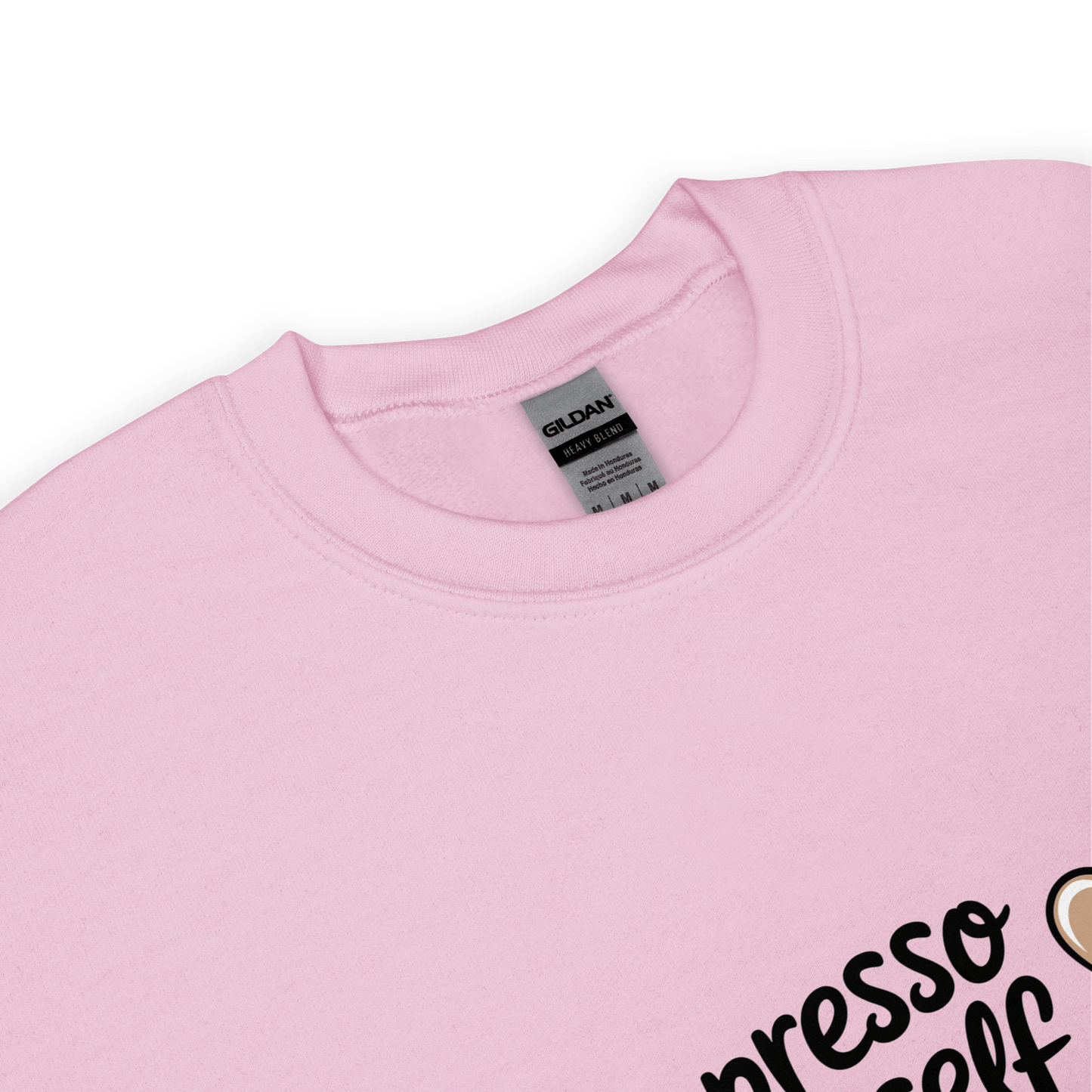 Close-up of a soft pink crewneck sweatshirt with the phrase “Espresso Yourself” printed in black cursive font and a small coffee cup illustration on the side.
