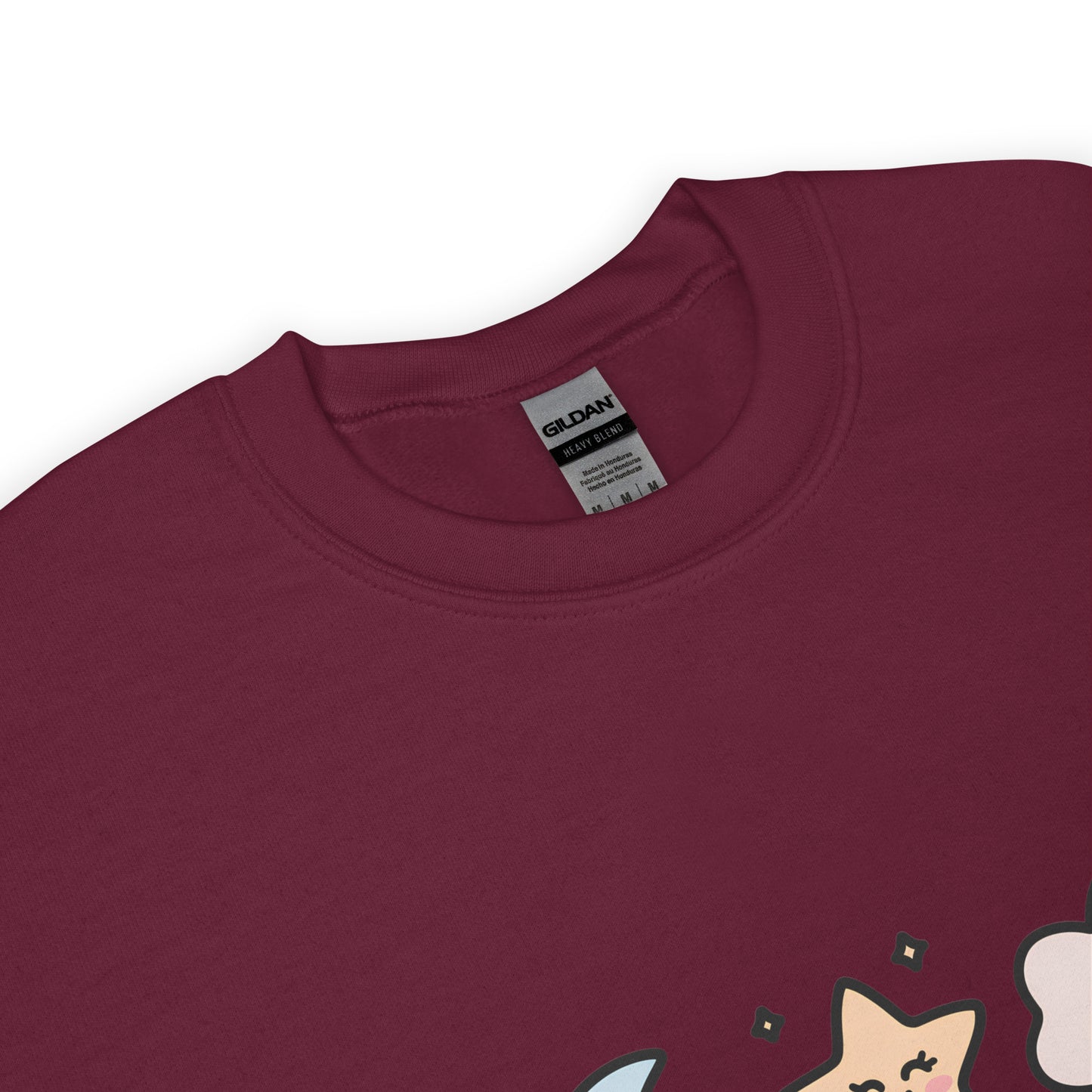 Close-up of the collar and tag of a light gray Gildan crew neck sweatshirt, with a partial view of a colorful star and cloud design at the bottom edge.
