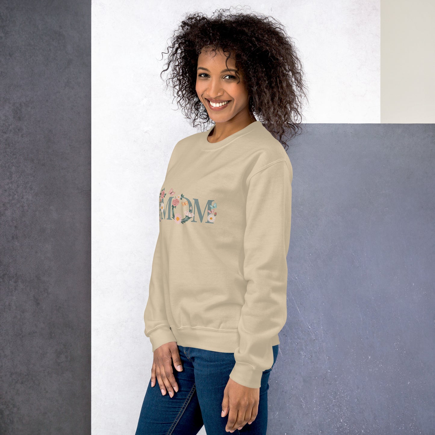 Smiling woman wearing a cream floral “MOM” sweatshirt – cozy and stylish gift idea for moms, shown from a side angle.