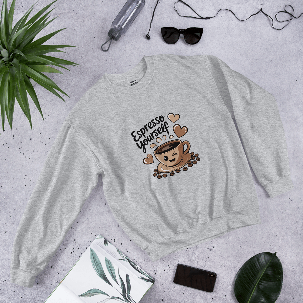 Grey “Espresso Yourself” sweatshirt styled flat lay with sunglasses, water bottle, plant, and notebook – cozy coffee lover gift aesthetic.