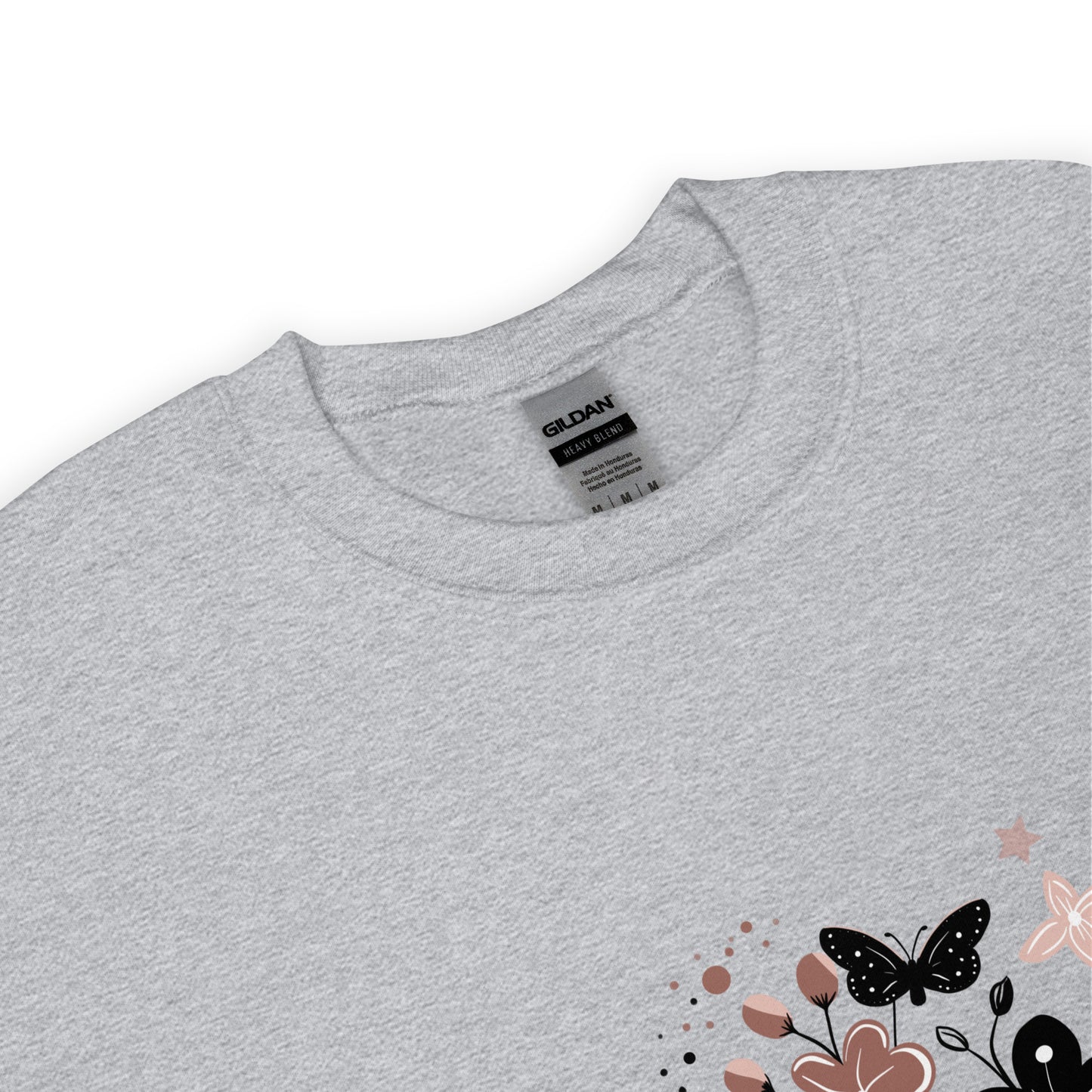 Close-up of a light sport gray Gildan sweatshirt with a floral and butterfly design printed on the lower corner, showing the collar and fabric texture.