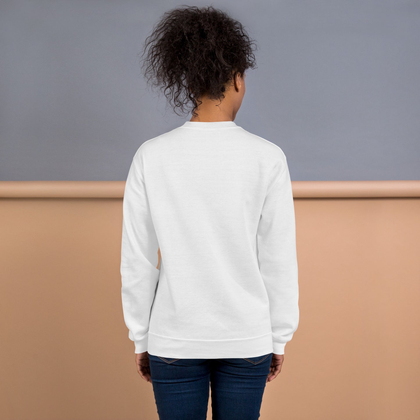 Back view of a woman wearing a white crewneck sweatshirt – soft cotton blend, relaxed fit, no print on the back.