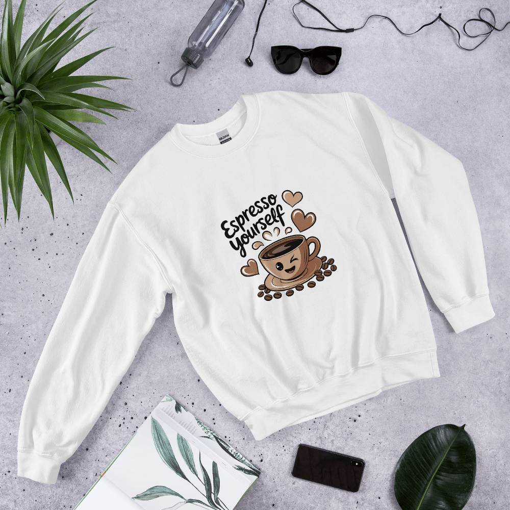 White “Espresso Yourself” sweatshirt styled flat lay with sunglasses, water bottle, plant, and notebook – cozy coffee lover gift aesthetic.