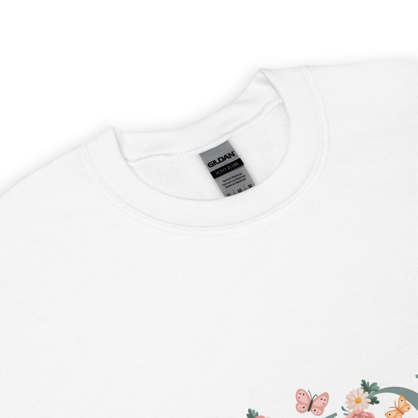 White crewneck sweatshirt with a close-up of the neckline and a small floral and butterfly design on the lower corner.