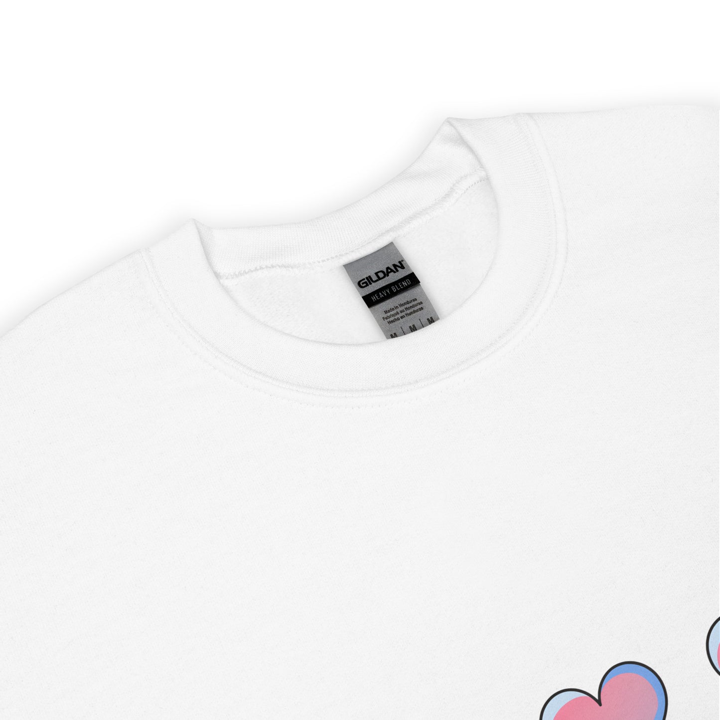 Close-up view of a white crewneck sweatshirt with a soft texture, featuring the top part of a pastel heart design near the hem