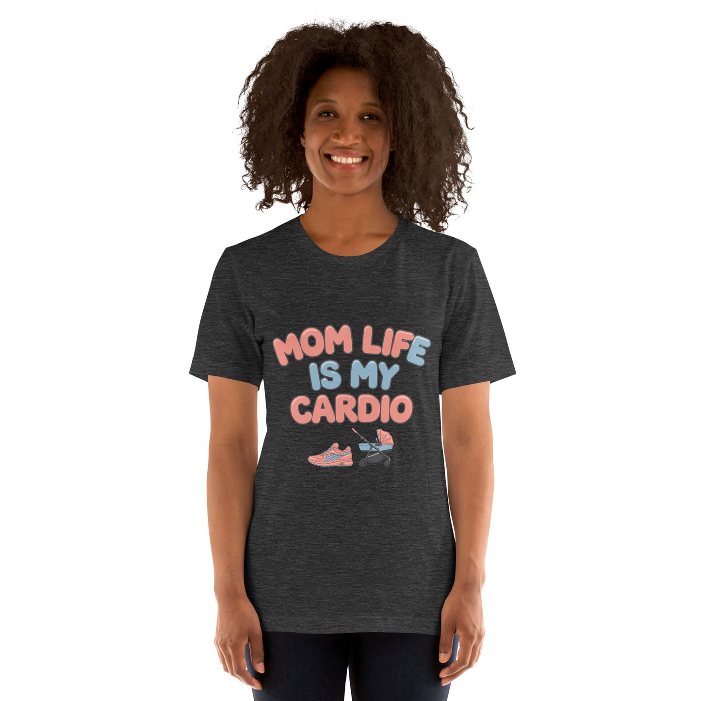 Smiling woman wearing a dark grey unisex t-shirt with pastel text that says 'Mom Life Is My Cardio' and graphics of sneakers and a pacifier, standing against a white background.