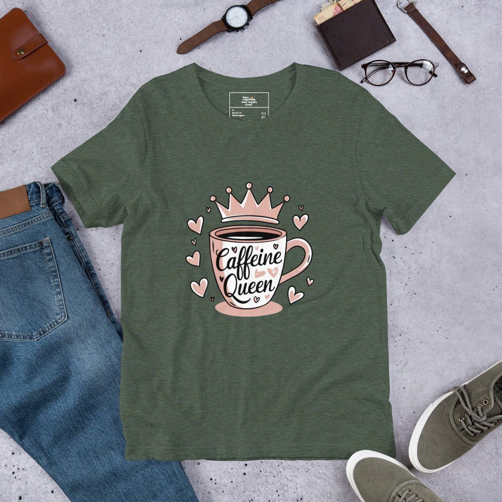 Flat lay of a green unisex t-shirt with a pink “Caffeine Queen” coffee cup design, styled with jeans, sneakers, and accessories.