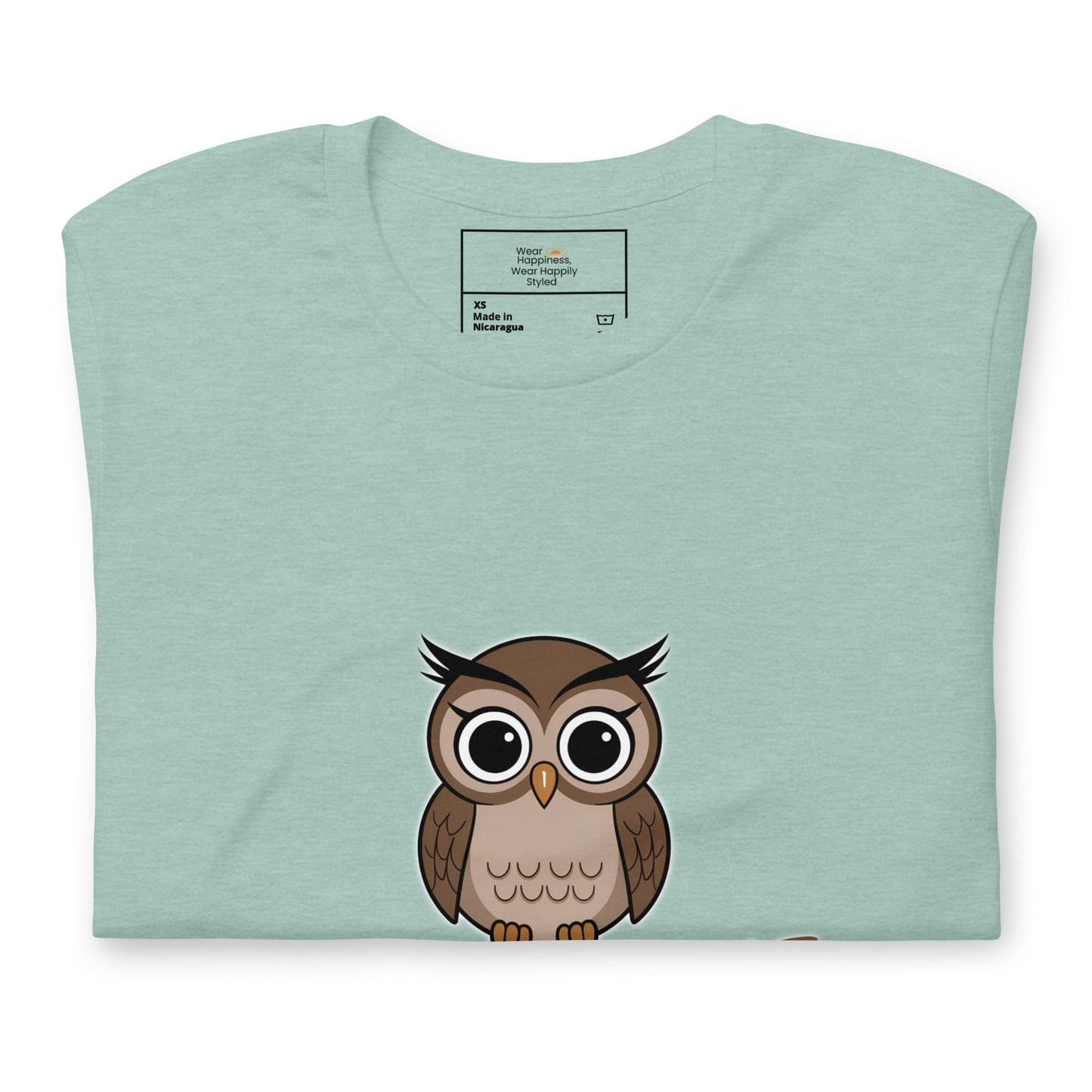 Close-up of a dusty blue t-shirt with a cute cartoon owl graphic peeking from the bottom