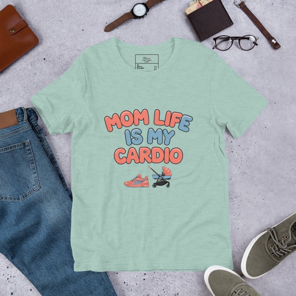 Dusty blue unisex t-shirt laid flat on a surface next to jeans and accessories, featuring the phrase 'Mom Life Is My Cardio' in pastel letters with sneakers and pacifier graphic.