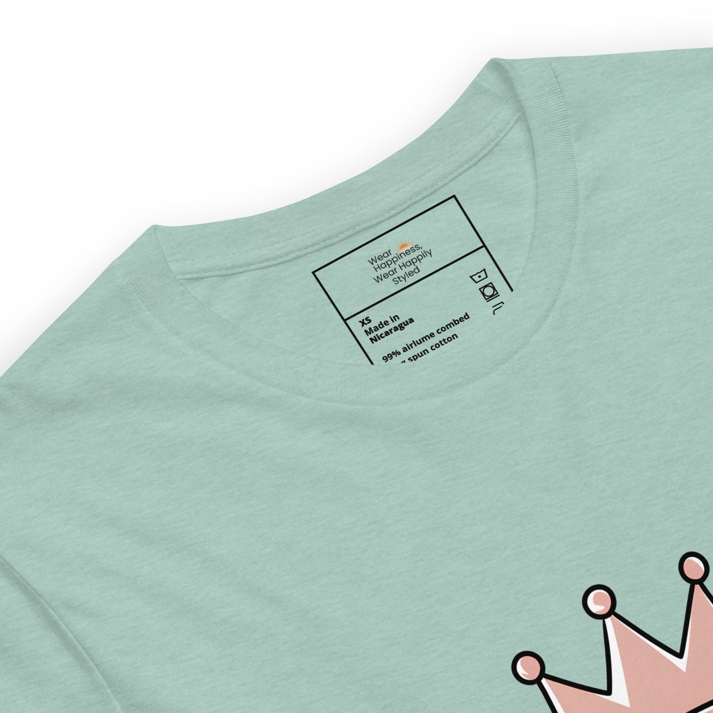 Close-up of a heather dusty blue unisex t-shirt showing printed inner label and partial “Caffeine Queen” crown design