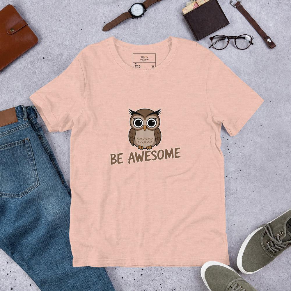 Flat lay of a heather peach t-shirt with a cute owl and “Be Awesome” text – styled with jeans, shoes, and accessories.