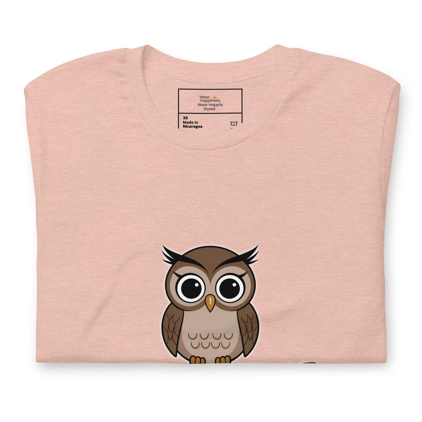 Close-up of a heather peach t-shirt with a cute cartoon owl graphic peeking from the bottom