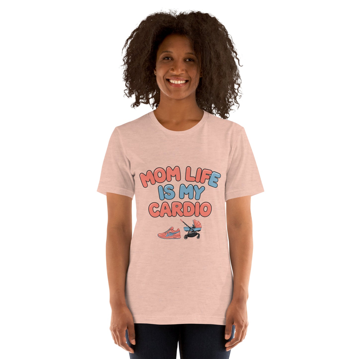 Smiling woman wearing a peach unisex t-shirt with pastel text that says 'Mom Life Is My Cardio' and graphics of sneakers and a pacifier, standing against a white background.
