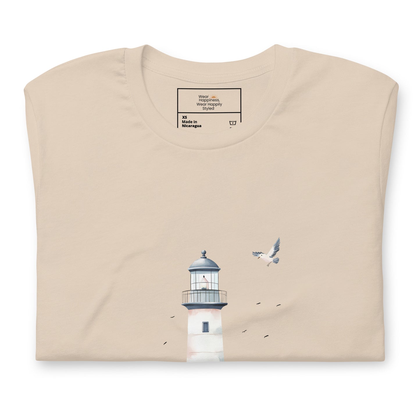 Flat-lay of a folded soft cream-colored t-shirt featuring a minimal lighthouse and seagull design, styled for a calming, nature-inspired mom aesthetic.