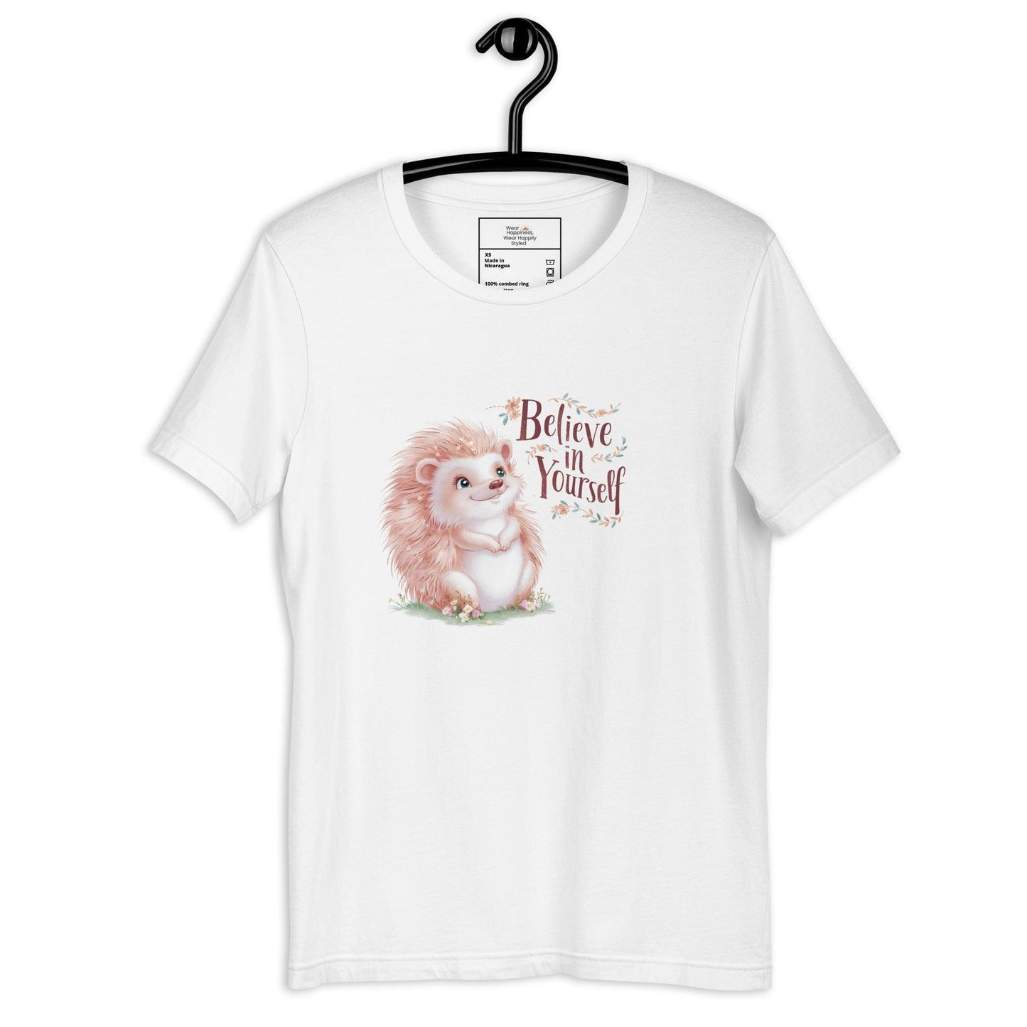 Hanging white t-shirt with a pastel hedgehog and “Believe in Yourself” quote