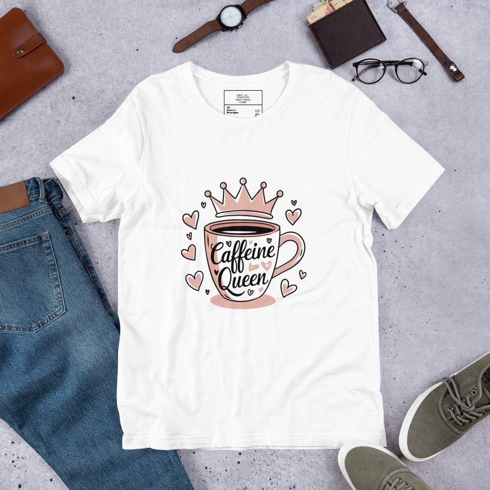 Flat lay of a white unisex t-shirt with a pink “Caffeine Queen” coffee cup design, styled with jeans, sneakers, and accessories.