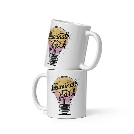 Two stacked white mugs with “Illuminate Your Path” lightbulb design, arranged playfully on a white background