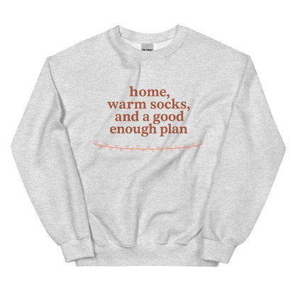 Gray sweatshirt with red text "home, warm socks, and a good enough plan" on a white background