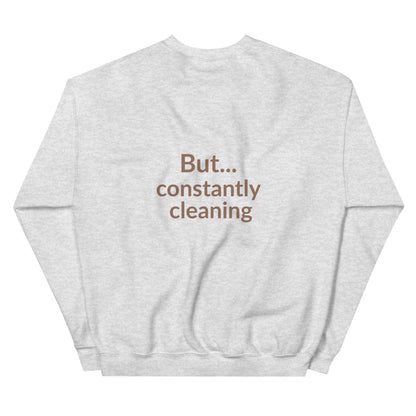 Gray sweatshirt with text 'But... constantly cleaning' on a white background