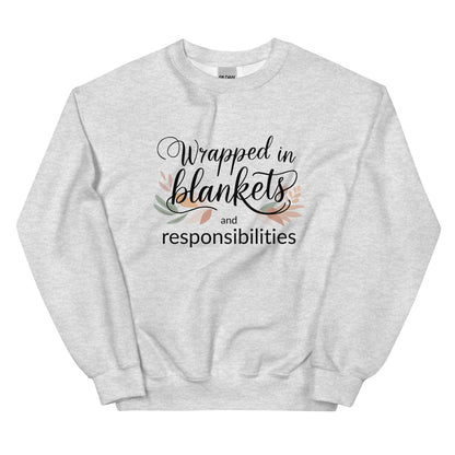 Gray sweatshirt with text 'Wrapped in blankets and responsibilities' on a white background