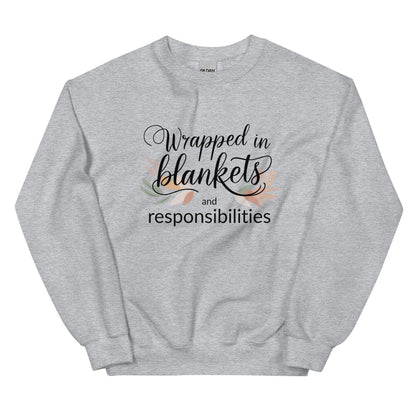Gray sweatshirt with text 'Wrapped in blankets and responsibilities' on a white background