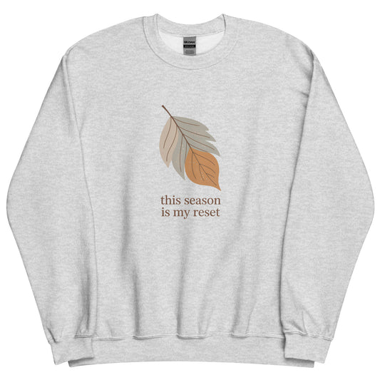 Gray sweatshirt with leaf graphic and text 'this season is my reset' on a white background