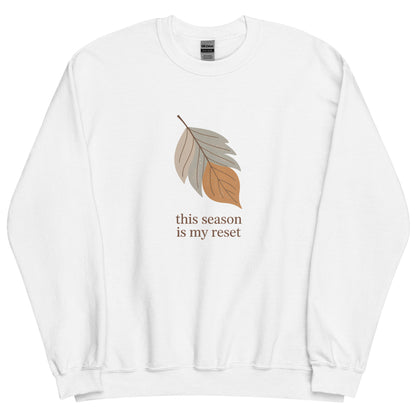 White sweatshirt with a leaf graphic and text "this season is my reset" on a white background